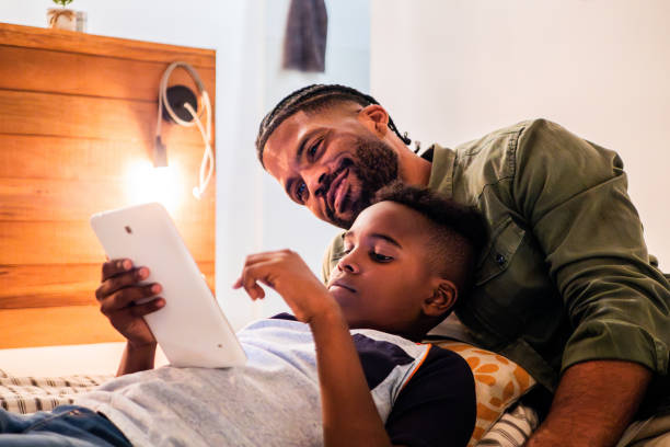 istock Child boy using digital tablet and talking to father at home 2190963356