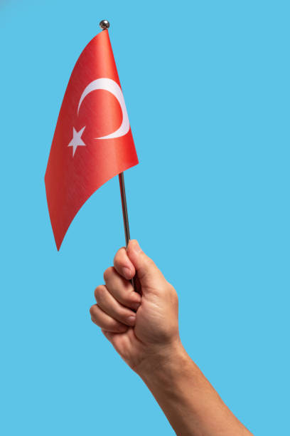 istock Hand holding Turkey flag in front of blue background with copy space. 2190965794