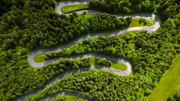 istock Aerial Drone View of Winding Road Through Dense Pine Forest 2190966197