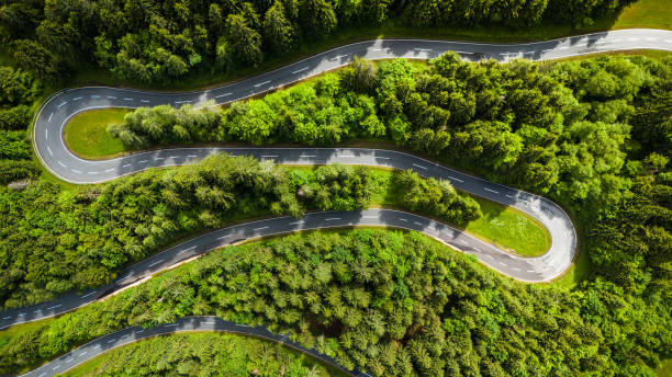 istock Aerial Drone View of Winding Road Through Dense Pine Forest 2190967119
