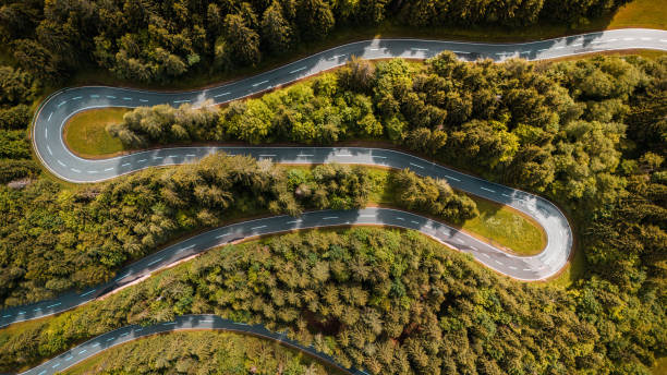 istock Aerial Drone View of Winding Road Through Dense Pine Forest 2190967287