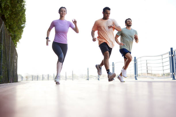 Jogging at a fast pace, friends enjoy a weekend in the public park.