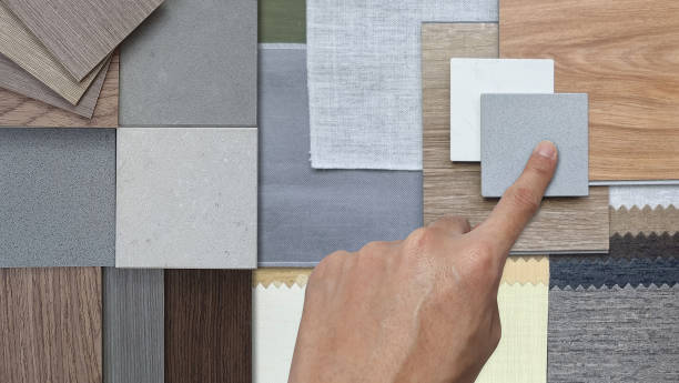 istock interior designer chooses material samples, including various wood veneers, fabric swatches, stone or concrete tiles, wooden vinyl floor tiles arranged closely together to display. 2190969824