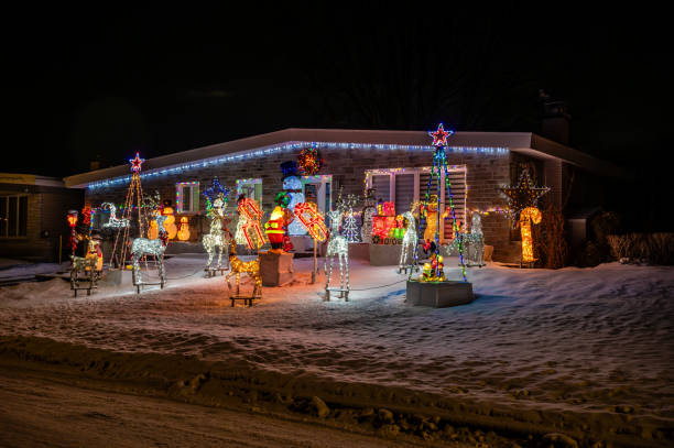 Residential home facade decoration during winter night in Quebec city, fully decorated with illuminated reindeers, Santa, trees, stars, candy canes, snowmen, gift, sleigh.