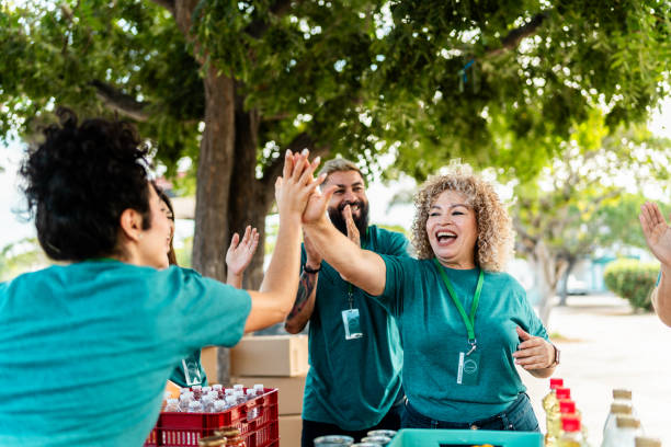 Volunteer organizing donation boxes and doing high-five outdoors