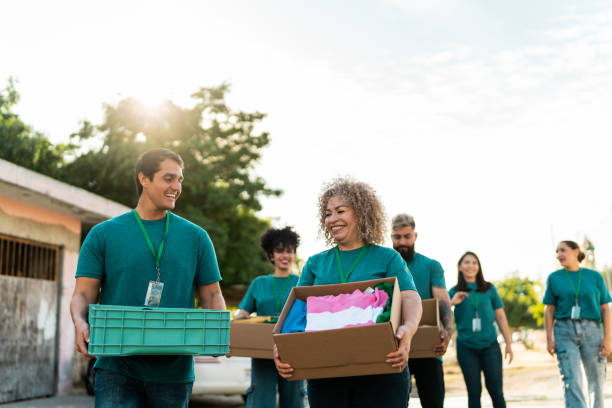 istock Volunteers talking and walking with donation boxes outdoors 2190974489