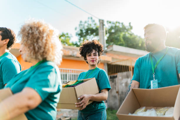 istock Volunteers talking and walking with donation boxes outdoors 2190974567