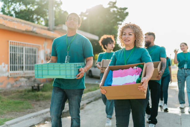 istock Volunteers talking and walking with donation boxes outdoors 2190974581