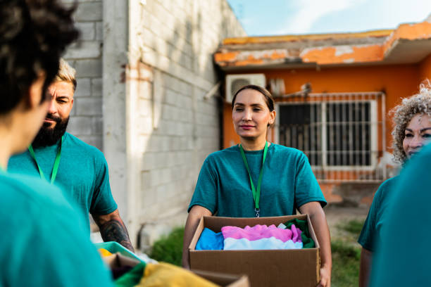 istock Volunteers talking and holding donation boxes outdoors 2190974934
