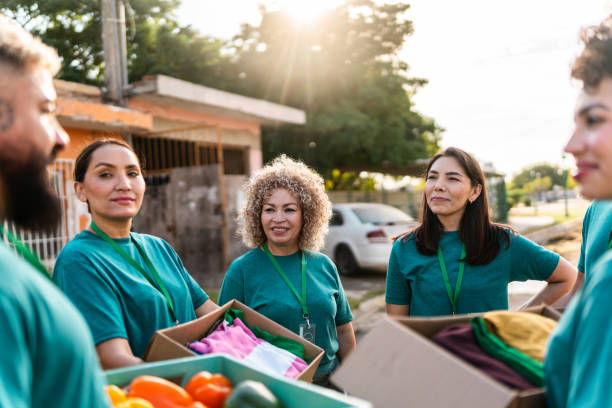 istock Volunteers talking and holding donation boxes outdoors 2190974936