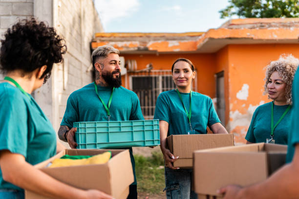 istock Volunteers talking and holding donation boxes outdoors 2190974951