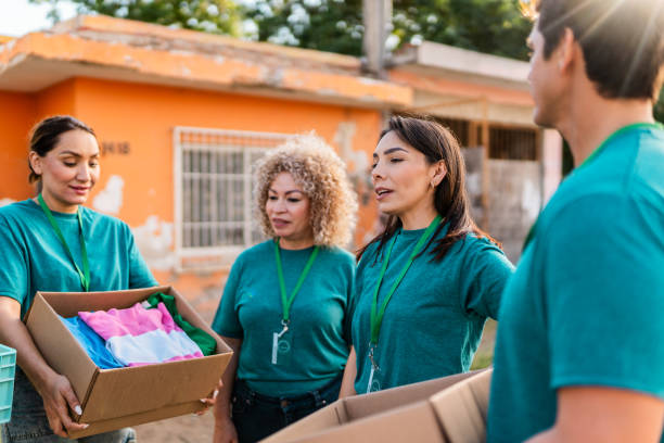 istock Volunteers talking and holding donation boxes outdoors 2190974956