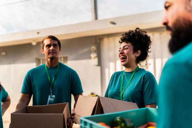 istock Volunteers talking and holding donation boxes outdoors 2190974964