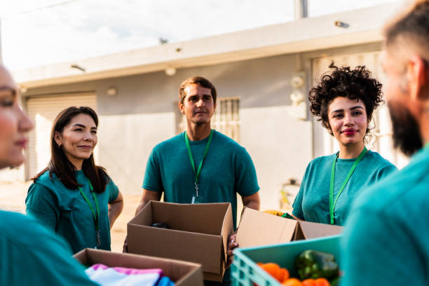istock Volunteers talking and holding donation boxes outdoors 2190974969