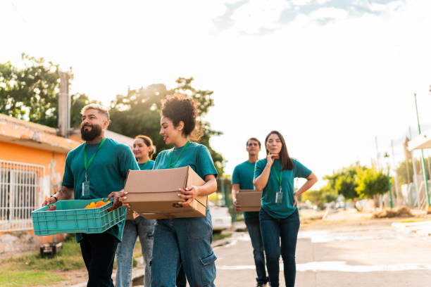 istock Volunteers talking and walking with donation boxes outdoors 2190975753