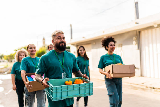 istock Volunteers talking and walking with donation boxes outdoors 2190975764