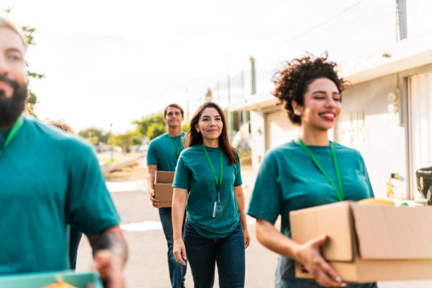istock Volunteers talking and walking with donation boxes outdoors 2190975769