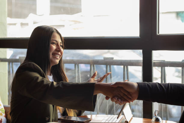istock Young businesswoman in office, smiling while shaking hands during a deal with her teamwork 2190977742