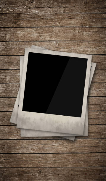 Two blank instant photos laying on a wooden table
