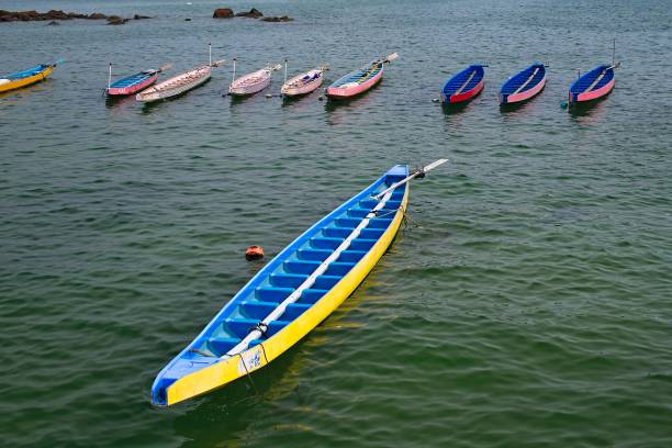 Colorful kayaks and canoes on a boat rack with reflection in calm water