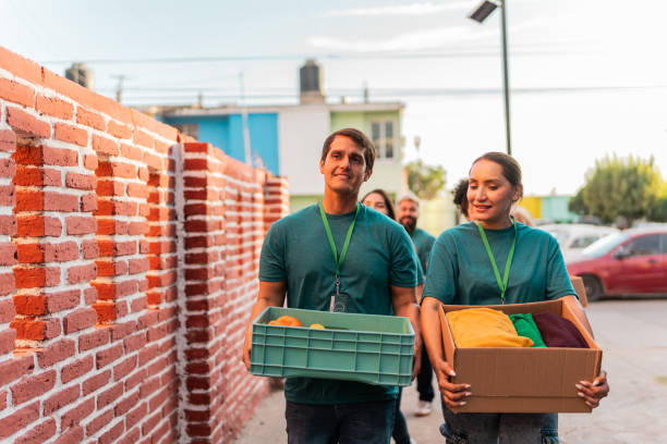 istock Volunteers talking and walking with donation boxes outdoors 2190983976