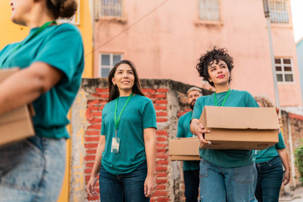istock Volunteers talking and walking with donation boxes outdoors 2190983982