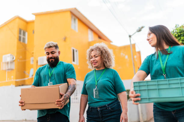 istock Volunteers talking and walking with donation boxes outdoors 2190983991
