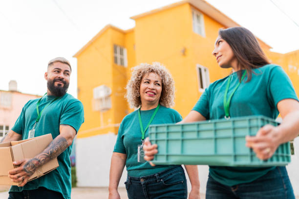 istock Volunteers talking and walking with donation boxes outdoors 2190983995