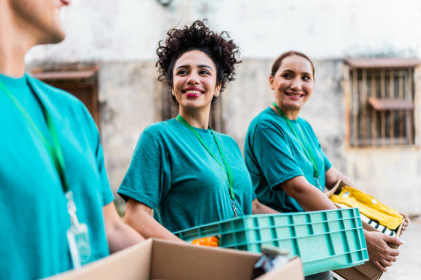 istock Volunteers talking and walking with donation boxes outdoors 2190984001