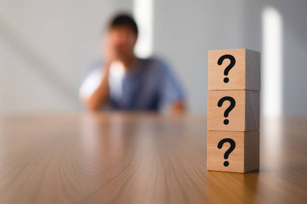 Wooden cube sign question mark symbol on wood table with man action worry, doubt and confuse. Blur motion background. thinking of problems for idea QA, question and answer concept