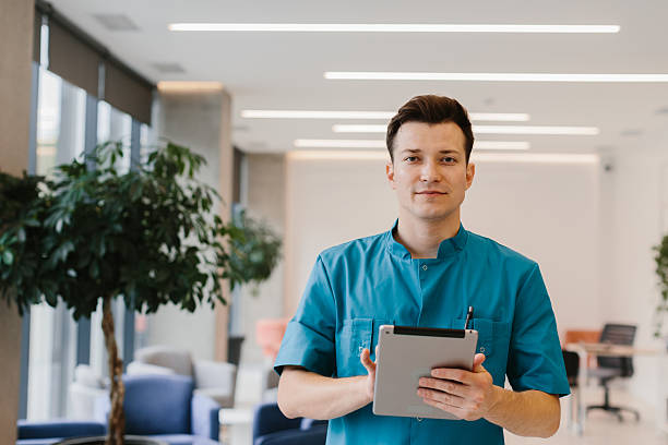 istock Young doctor holding a tablet and looking at the camera in a modern clinic. 2190996567