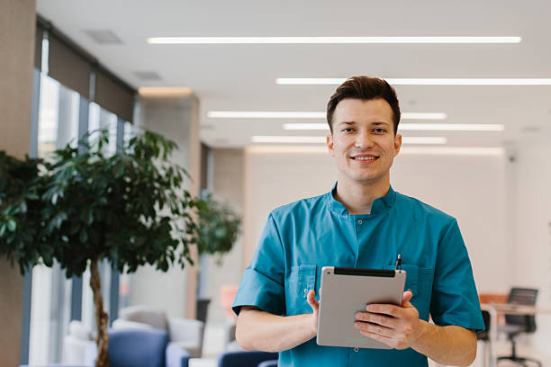 istock Young doctor holding a tablet and looking at the camera in a modern clinic. 2190996569