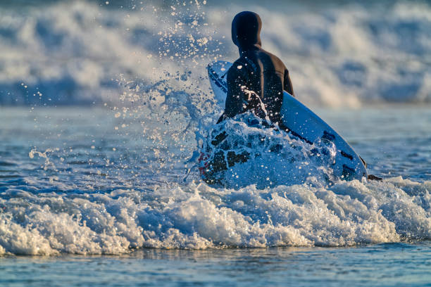 Rio de Janeiro, Brazil - April 22, 2014:  Bather is seen practicing surfing on the Recreio dos Bandeirantes beach, a noble neighborhood located in the western area of Rio de Janeiro.