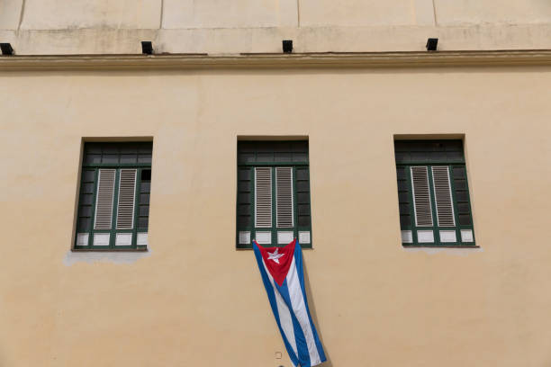 Cuba, Havana, building, shuttered windows, Cuban flag. 2016-03-25