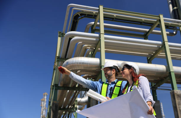 istock A dedicated team of project engineers diligently examines detailed blueprints as they inspect the vital pipeline system at the chemical plant, ensuring safety and efficiency in operation. 2191007641