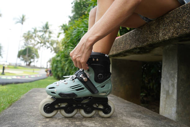 istock A woman is sitting on a bench and putting on her roller skates 2191019257