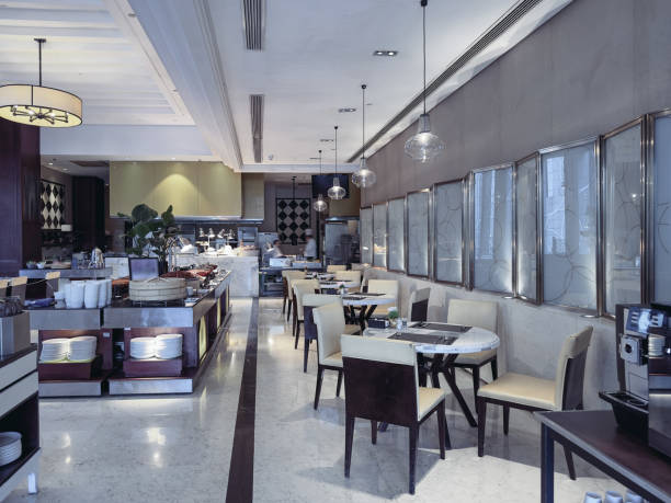 istock A modern and elegant restaurant interior with neatly arranged dining tables and chairs, featuring marble tabletops and soft lighting. 2191024478