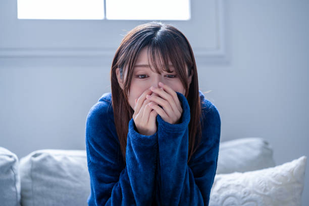 体調不良で冷えを感じる日本人女性 - 不安 日本人 ストックフォトと画像