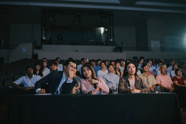 istock Asian panel judges whispering listening giving score to stage performance competition in front of audience 2191026729