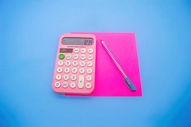 istock A pink calculator displaying 1234 on a blue background, accompanied by a pink pen and a pink notepad, creating a vibrant and colorful study setup 2191026763