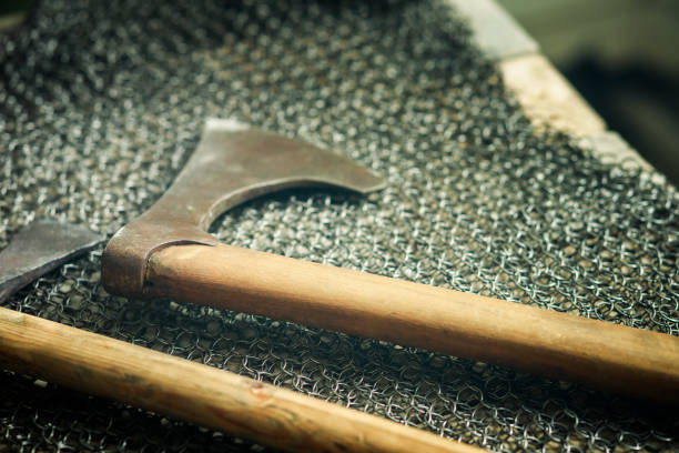 battle axe close-up on chain mail, shallow depth of field. steel axe and wooden handle