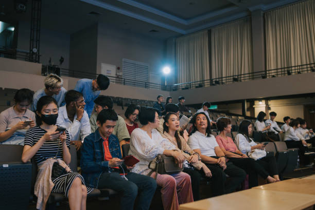 istock Enthusiastic Asian mixed aged audience entering  and seating in auditorium 2191027057