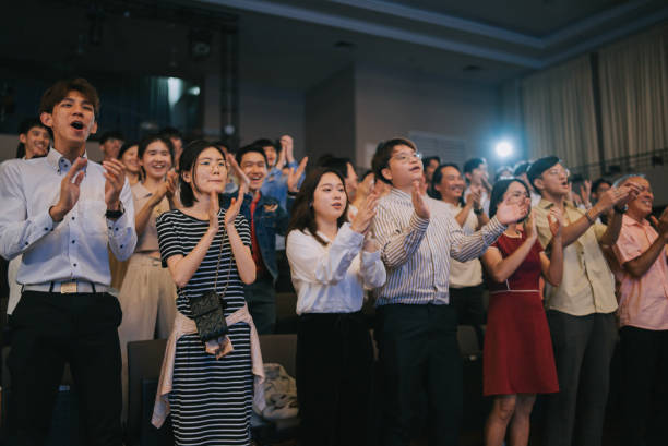 istock Enthusiastic Asian mixed aged audience standing applause cheering at auditorium 2191027142