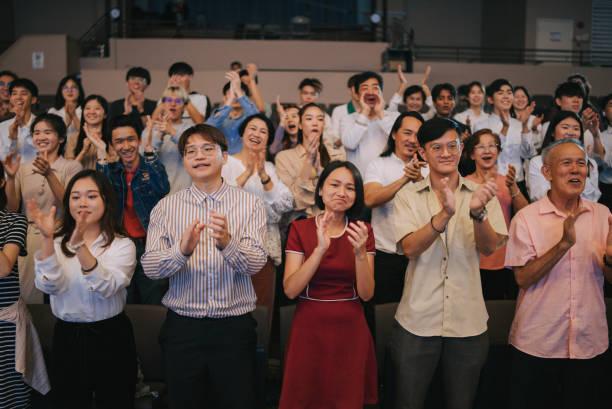 istock Enthusiastic Asian mixed aged audience standing applause cheering at auditorium 2191027172