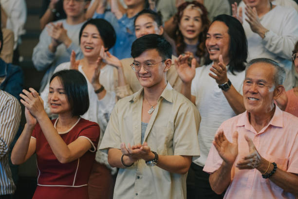 istock Enthusiastic Asian mixed aged audience clapping hands cheering at auditorium 2191027180