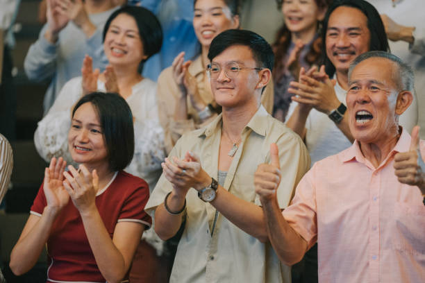 istock Enthusiastic Asian mixed aged audience clapping hands cheering at auditorium 2191027181