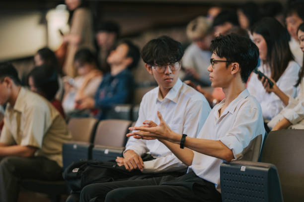 Asian young audience sitting in auditorium waiting for the stage performance to start
