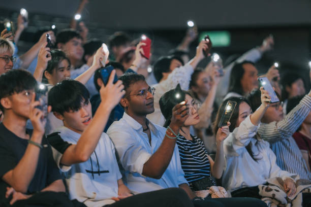 istock Asian audience waving phone with flashlight singing along At Concert 2191027441