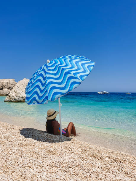 istock Relaxing under a colorful umbrella on a serene beach, enjoying the warm sunlight and tranquil waves 2191028344