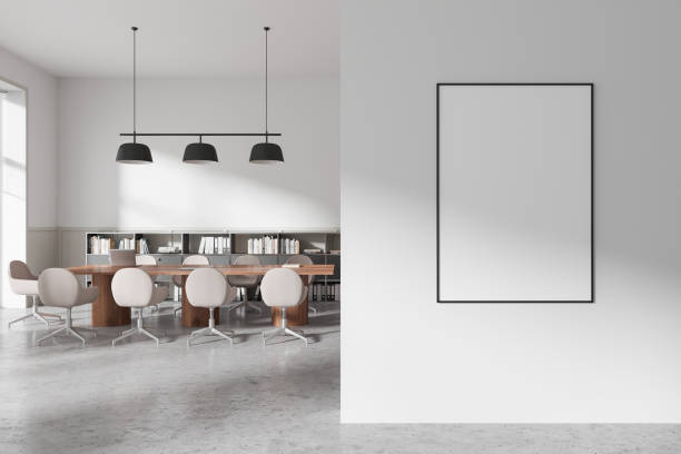 istock Blank poster mockup hanging on white wall in modern office with wooden table and chairs, suitable for art or display layout concepts. 3D Rendering 2191028351